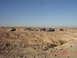 1996 Ford Bronco - A group of off-road vehicles are gathered in a desert area, with a large eroded ditch in the foreground.