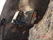 1996 Ford Bronco - Two off-road trucks are stuck on a steep rocky incline, one being pulled by a winch.
