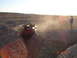 1996 Ford Bronco - A red Jeep Wrangler navigates a steep dirt ravine, with a person watching from the rim.