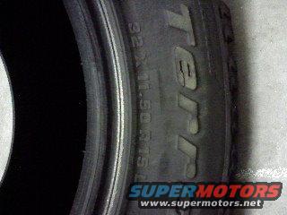 Close-up of a tire with "TERRAIN" visible. Supermotors.net logo at bottom