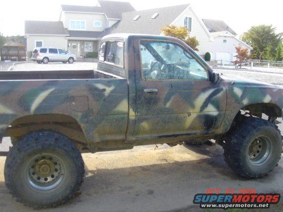 Side view of a 1992 Toyota Tacoma pickup truck with camouflage paint and lifted suspension