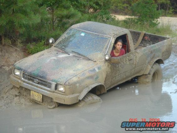 1992 Toyota Tacoma stuck in mud, driver looking out window. License plate is visible