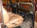 1979 Ford F-150 - The interior of a 1979 Ford F-150 features tan seats, wood grain trim on the dashboard, and Ford-branded floor mats.