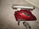 2003 Suzuki Bandit S - A motorcycle's exhaust and a damaged red fairing are shown on a concrete floor.