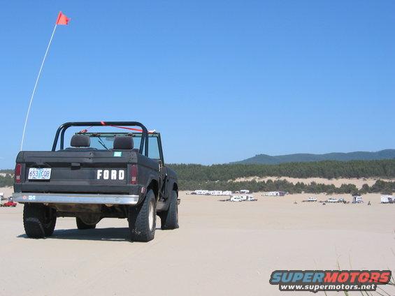 1968 Ford Bronco rear view on sand dunes with orange flag