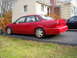 1995 Ford Taurus - Red 1995 Ford Taurus parked on asphalt in front of a beige house.