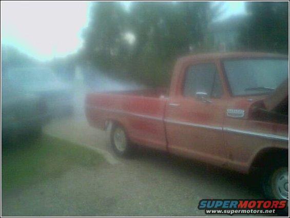 Red pickup truck with chrome trim and a badge on the fender