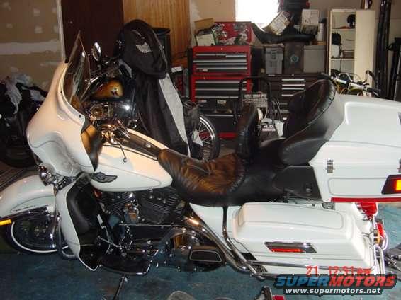 Motorcycle with white fairing, black leather seat, and saddlebags