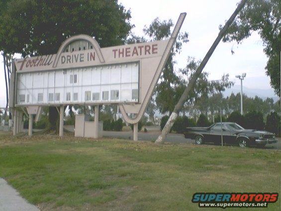 Black 1973 Ford Ranchero parked by a drive-in theater sign