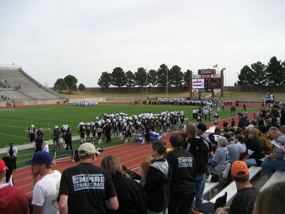 Football stadium with teams on field and spectators in bleachers
