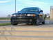 2001 BMW 3 Series - A black 2001 BMW 3 Series sedan is parked on concrete steps under a blue sky.