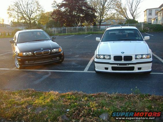 2001 BMW 3 Series sedan, black, parked next to a white 2001 BMW 3 Series sedan