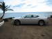2006 Dodge Charger - Side view of a silver 2006 Dodge Charger parked on a dirt lot next to the ocean.