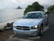 2006 Dodge Charger - A silver Dodge Charger is parked on the side of the road near a beach with a unique island formation in the ocean.