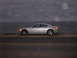 2006 Dodge Charger - A silver sedan is parked on a road overlooking the ocean under a cloudy sky.