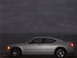2006 Dodge Charger - A silver 2006 Dodge Charger is parked on the shore with the ocean in the background under a cloudy sky.