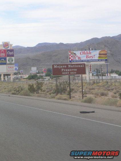 Roadside scene with billboards for Burger King, Cici's, and Mojave National Preserve