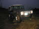 1968 Ford Bronco - This dark SUV with a white top appears to be stuck in muddy terrain at dusk.