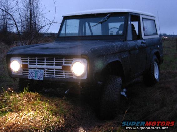 Front view of a 1968 Ford Bronco in a muddy field
