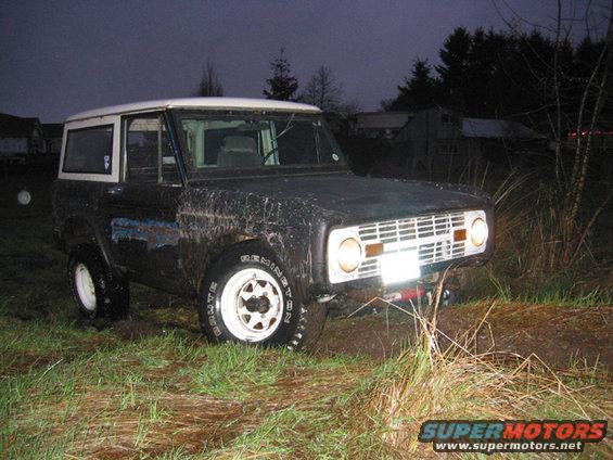 1968 Ford Bronco in mud, 3/4 front view, dark body, white top and wheels