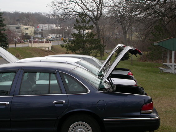 Dark blue 2001 Ford Crown Victoria with open trunk, parked in a line