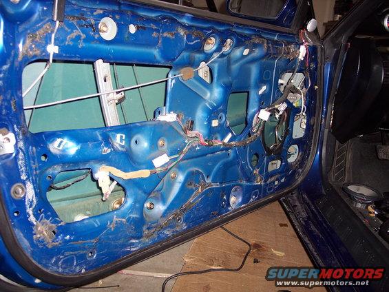 Blue door interior with exposed wiring and window mechanism