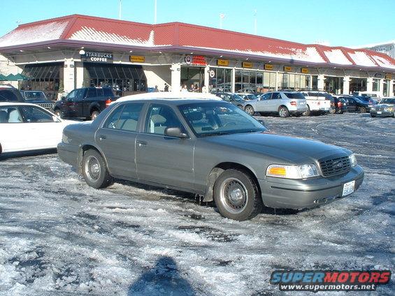 Gray 2000 Ford Crown Victoria parked in a snowy lot in front of a Starbucks