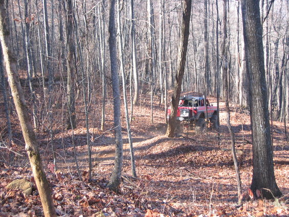 Red off-road vehicle on a dirt path in a forest
