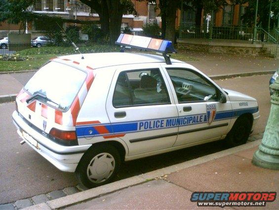 White police car with blue and red stripes, marked 'POLICE MUNICIPALE', parked on a street