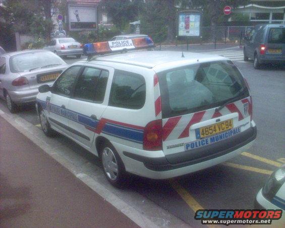 White police wagon with red and white stripes on the rear, "POLICE MUNICIPALE" text, and license plate 4654 VC94
