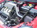 2005 Dodge SRT-4 - Close-up view of the engine bay in a red 2005 Dodge SRT-4, highlighting the SRT-4 branding and aftermarket modifications.