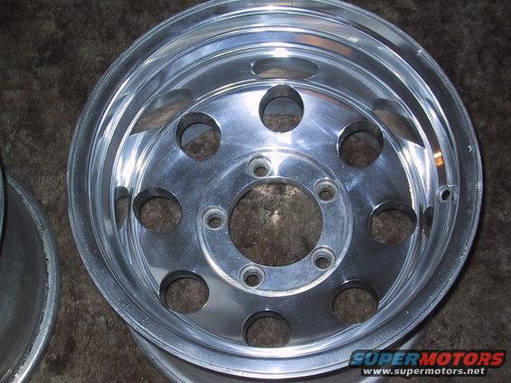 Aluminum wheel with 8 circular cutouts and 5 lug holes