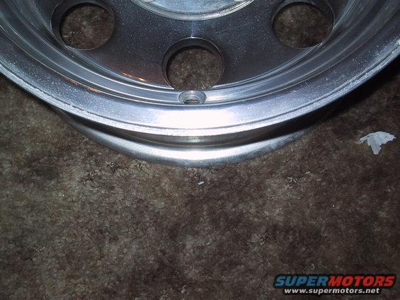 Close-up of a vehicle's aluminum wheel with lug nut holes
