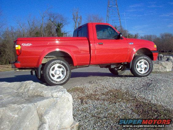 Red 2001 Mazda B3000 pickup truck parked on gravel with large rocks