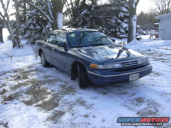Blue sedan parked in a snowy yard. License plate reads 498-HCV