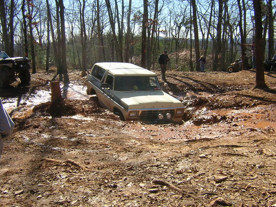 Ford Bronco stuck in mud pit with another off-road vehicle visible to the left