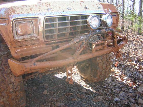 Mud-covered 1979 Ford Bronco front end with a winch and off-road bumper