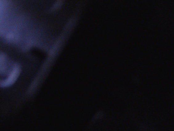 Image is almost entirely black with some faint blueish light on the left
