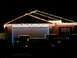 1997 Ford Probe - A house is adorned with festive lights, with several vehicles parked in the driveway under the night sky.