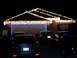 1997 Ford Probe - A house is adorned with festive Christmas lights, with several vehicles parked in front.