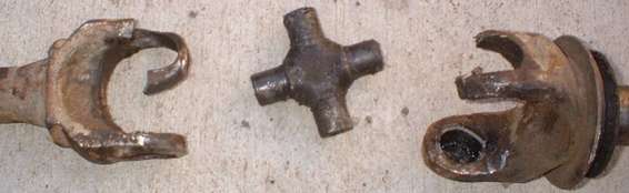 Driveshaft universal joints, one with a broken yoke, and a cross spider joint