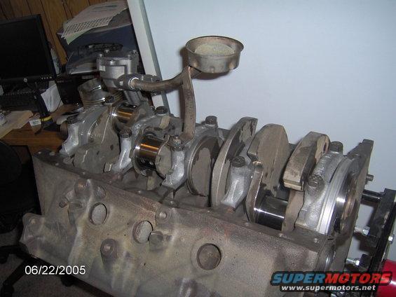 Engine block with crankshaft and oil pickup tube visible. Some parts are shiny, others are dirty