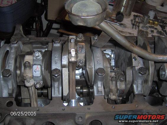 Engine block with crankshaft and connecting rods, oil pickup tube visible