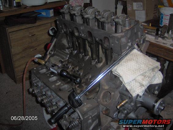 Engine block with valve train components visible, torque wrench attached. Date stamp 06/28/2005