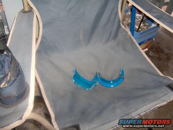 Two broken blue plastic pieces resting on a gray folding chair