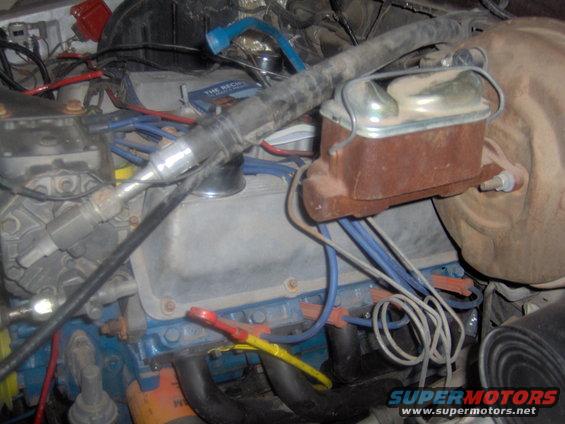 Engine bay with blue engine block, brake master cylinder, and wiring