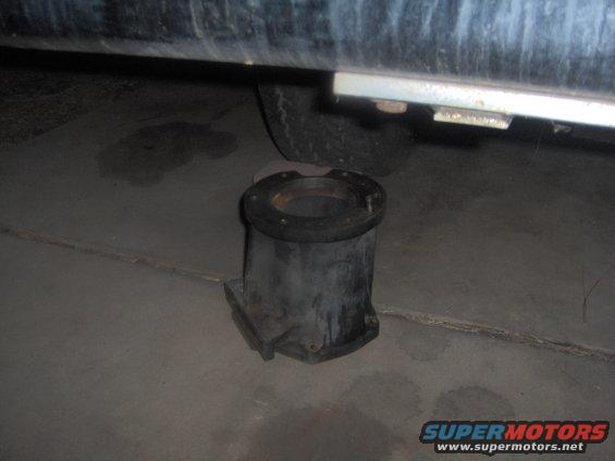 Exhaust pipe flange resting on concrete under a vehicle
