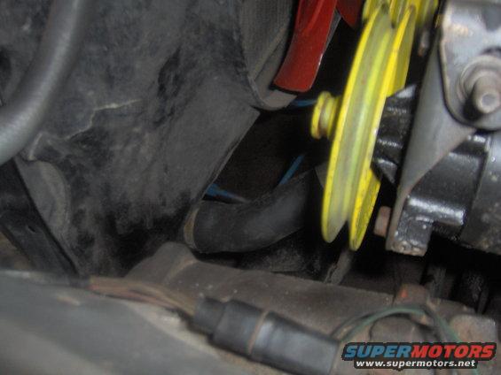 Engine bay detail with yellow pulley and red fan blade