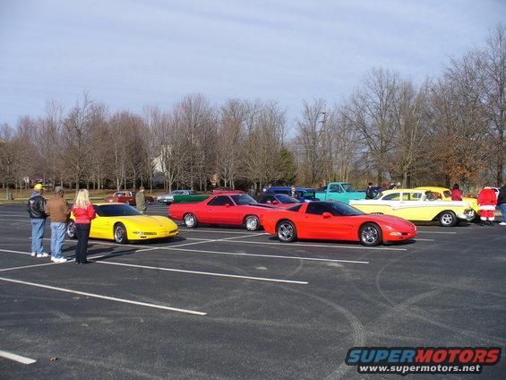 Red sports car parked in a lot with other vehicles