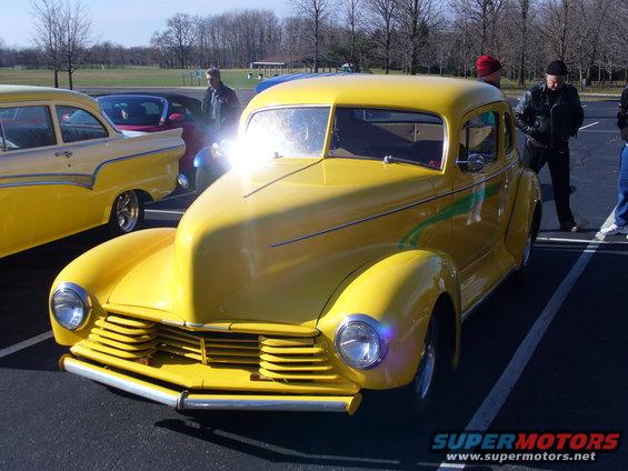Yellow hot rod with green stripes, front 3/4 view